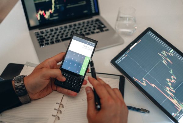 Man using a calculator to calculate landed cost and import charges at a desk