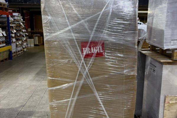 Pallet of printed packaging boxes with shipping documents attached, prepared for UK delivery