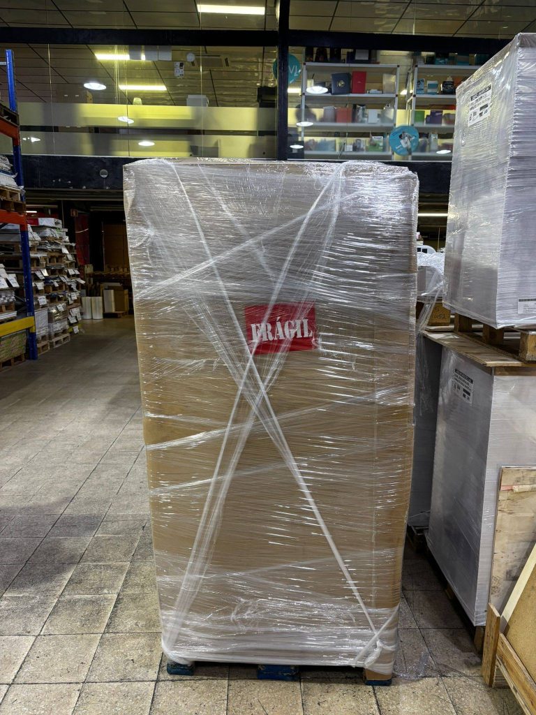 Pallet of printed packaging boxes with shipping documents attached, prepared for UK delivery