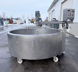Side view of a large stainless steel cheese vat mixing machine outdoors